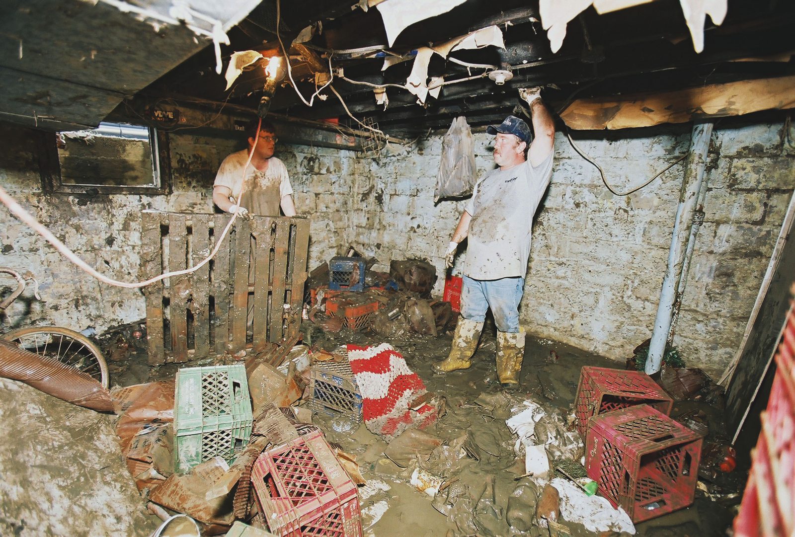 Salt Creek Restoration technician in waders clearing a flooded basement